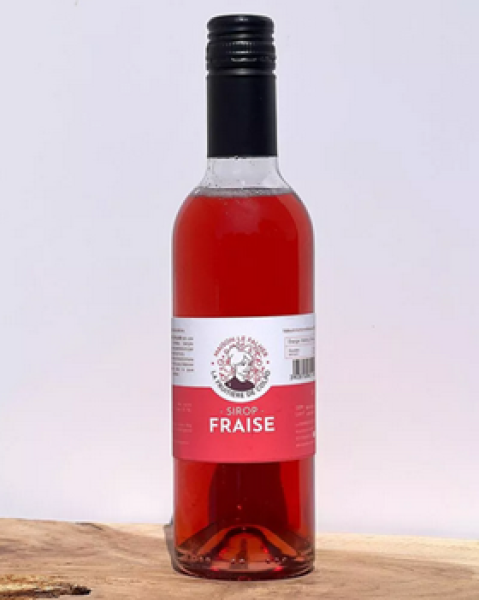 Erdbeersirup in Glasflasche neben frischen Erdbeeren